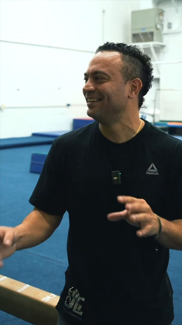 Coach Fuentes laughing with athletes on the floor at JLF Elite